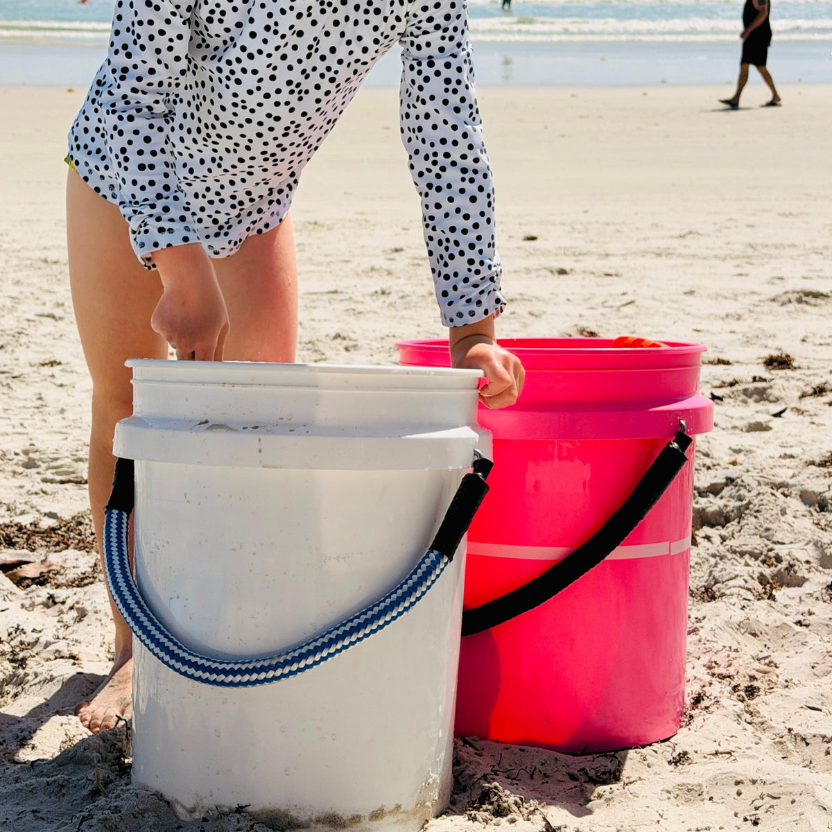 Two 5-gallon buckets with Cast & Carry rope handles on the beach
